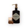 Hendrick's gin soap dispenser with vintage gold pump on white background positioned next to a clear uneven shot glass and champagne cork